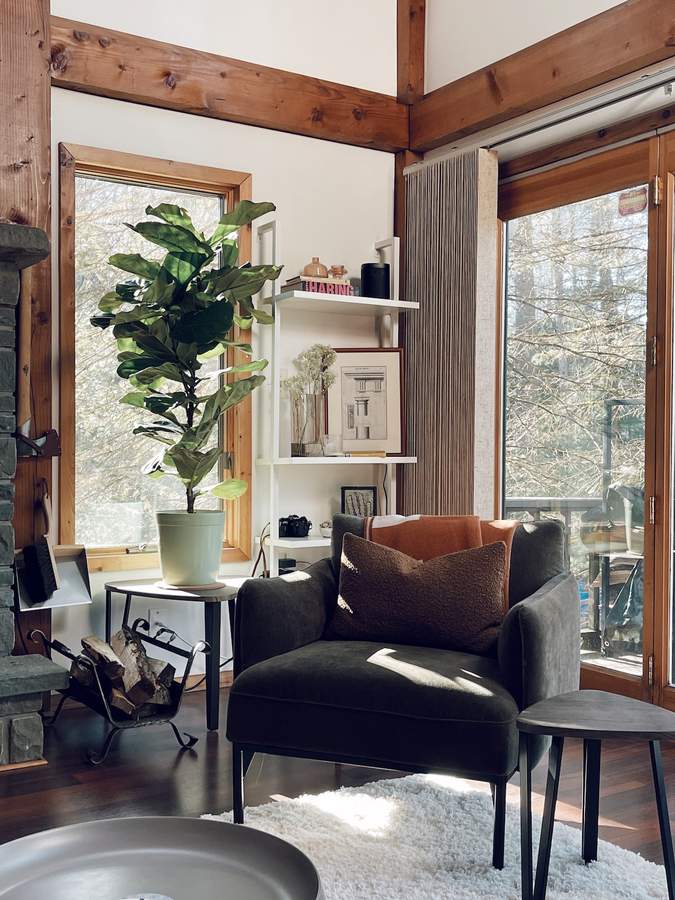 Living room with forest-facing windows at Lofty Cabin