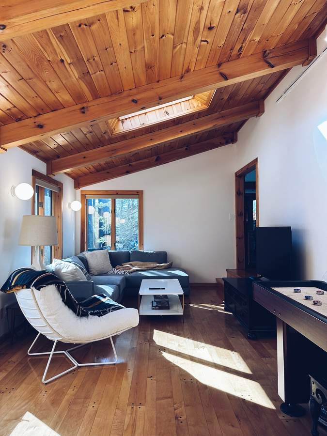 Den with sectional sofa and television at Lofty Cabin